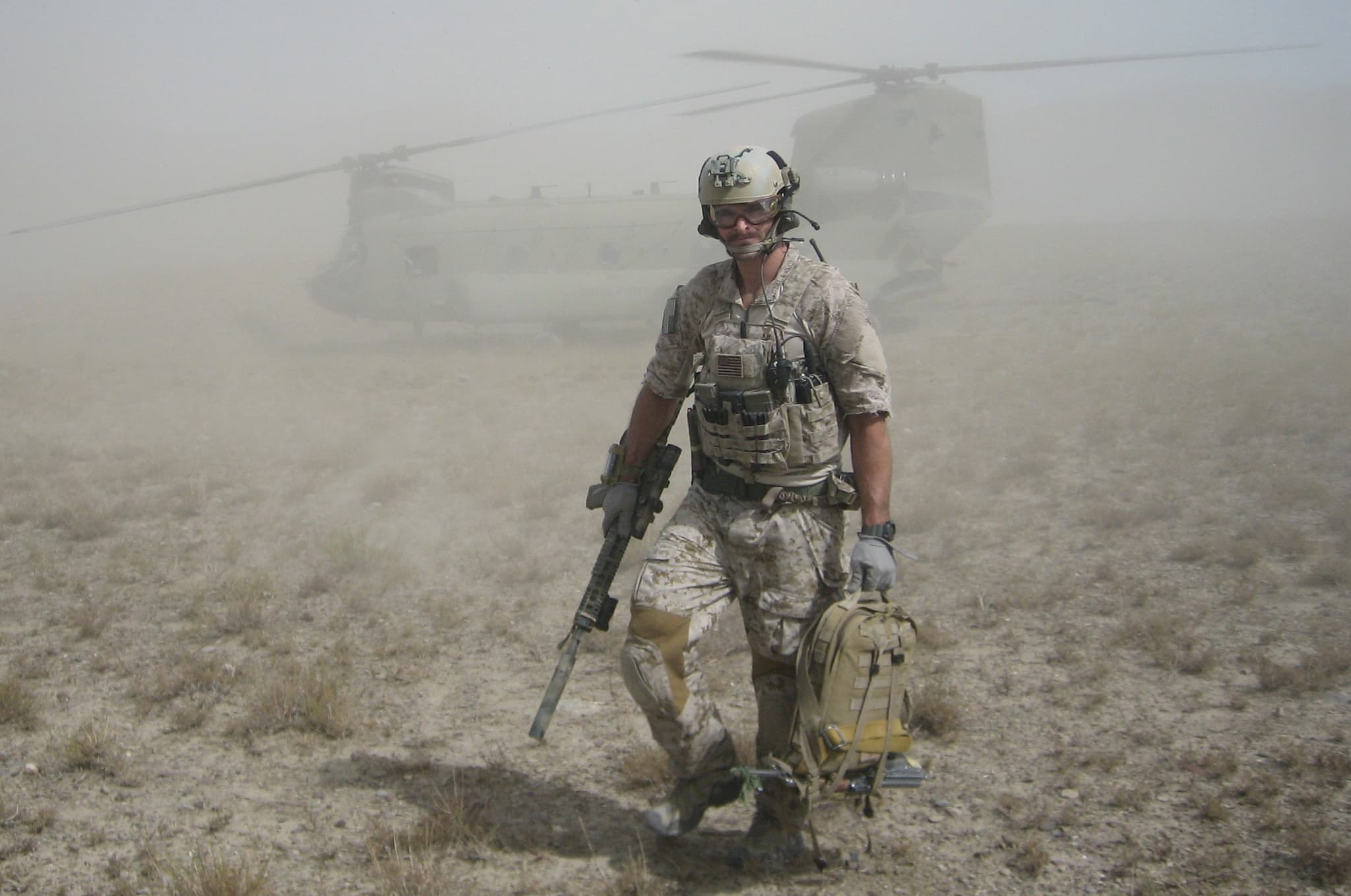 Joel Beam in full combat kit walking away from a Chinook helicopter in Afghanistan